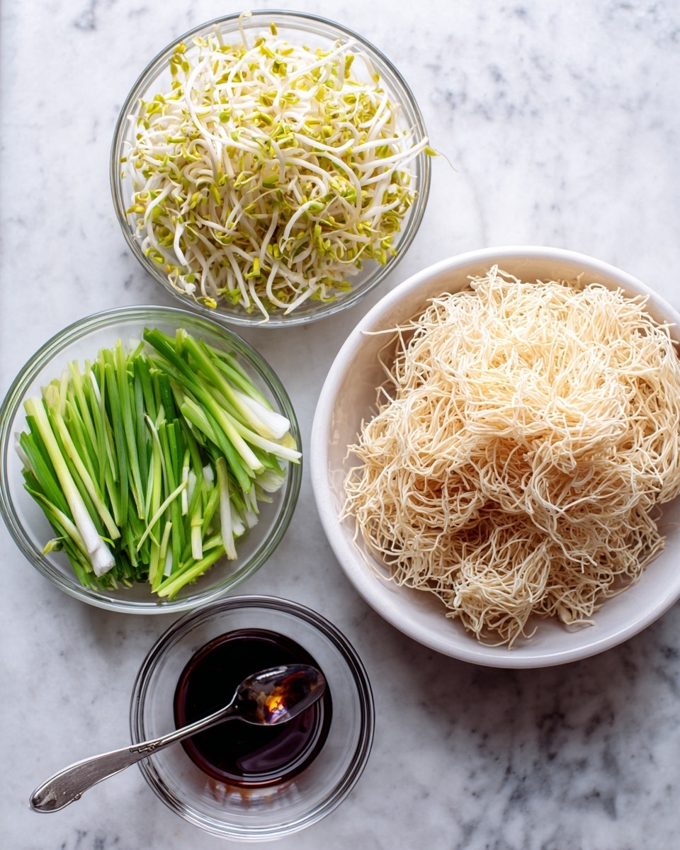 The image shows four white bowls and a glass bowl on a white marbled surface, each holding different ingredients. On the right side, there is a white bowl filled with a large amount of thin, light beige crispy noodles piled high. Above it, a glass bowl contains a heap of yellowish bean sprouts with white stems. To the left of the sprouts is another glass bowl filled with sliced green onions that are long, thin, and bright green with white parts. Below these two glass bowls is a smaller glass bowl holding a dark liquid sauce with a metal spoon resting inside. photo taken with an iphone --ar 4:5 --v 7