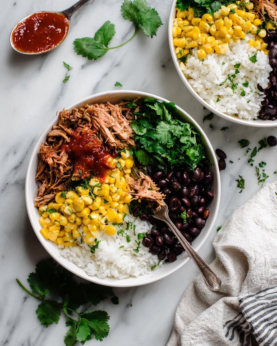 Two white bowls sit on a white marbled surface. Inside the bowl in front, there are four main layers arranged side by side: white rice at the bottom right, black beans next to the rice along the bottom left side, bright yellow corn piled over the rice and beans center, and shredded meat with a reddish sauce on the top left. The meat looks tender and moist, topped with some chopped green herbs. Fresh green cilantro sprigs rest on top of the corn and beans on the right side. A fork rests inside this bowl, with some meat on its tines. The second bowl in the upper right corner contains the same layered ingredients in a similar order. Near the top left side of the image, a spoon with red sauce rests on the white marbled surface. Scattered black beans and green cilantro leaves add extra color around the bowls. A white cloth with gray stripes lies under the front bowl. Photo taken with an iphone --ar 4:5 --v 7