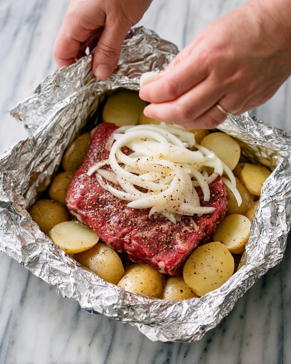 A piece of raw red steak with black pepper and salt seasoning sits on top of a layer of round, sliced yellow potatoes in a foil-lined container. A woman's hand sprinkles sliced white onions over the steak. Another woman's hand holds the edge of the foil. The scene is set on a white marbled surface. photo taken with an iphone --ar 4:5 --v 7