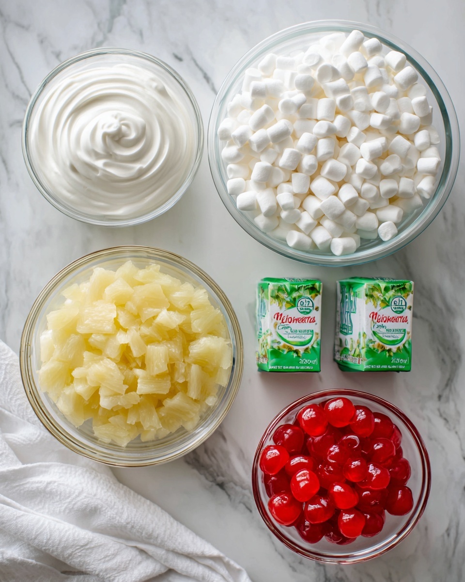 The image shows a top view of six ingredients neatly arranged on a white marbled surface. There is a large clear glass bowl filled with small, white mini marshmallows at the top right. Below it to the left, a smaller clear glass bowl holds smooth, white Cool Whip with soft swirls. In the center right, two small green and white boxes of Jell-O pistachio pudding mix are placed side by side. Below them, a medium clear glass bowl contains crushed pineapple with a yellowish, textured look and some juice around it. At the bottom right, a small clear glass bowl is filled with shiny, bright red maraschino cherries. The scene is bright and clean with a white cloth partially visible at the bottom left. The photo taken with an iphone --ar 4:5 --v 7