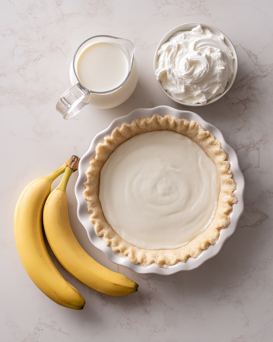 A top-down view shows a white pie crust shell with a scalloped edge placed on a white marbled surface. To the side, two whole yellow bananas with smooth peels lie next to a clear glass pitcher filled with white milk. Nearby, a small white bowl holds a fluffy white whipped topping, each item spaced neatly apart. The colors are soft and natural, highlighting the textures of the pie crust, bananas, and creamy milk and topping. Photo taken with an iphone --ar 4:5 --v 7