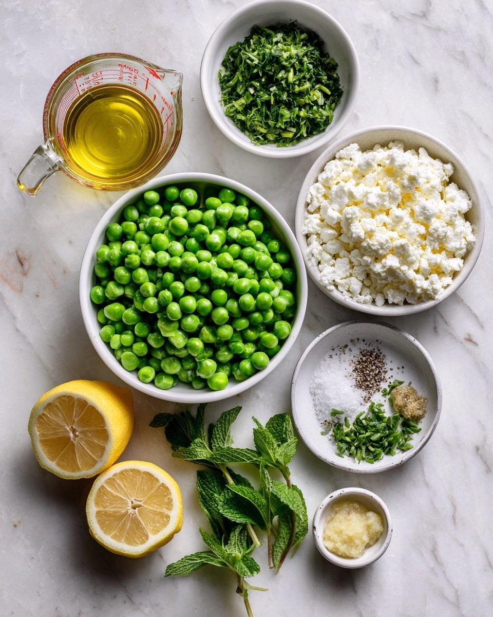 The image shows several fresh ingredients neatly arranged on a white marbled surface. At the center, a white bowl is full of bright green peas. To the right of it, there is a small white bowl filled with chopped green herbs, and above that, another white bowl with crumbly white cheese. Next to the cheese, there is a small saucer with salt and pepper mixed together, topped by green herb stems. To the left of the peas, two halves of a pale yellow lemon sit side by side. Below the lemons, some fresh green mint leaves and two small white bowls sit side by side; one bowl contains minced garlic, and the other has a dollop of grainy mustard. In the top left corner, a clear glass measuring cup filled with light golden oil rests on the surface. Everything is placed neatly and evenly spaced. Photo taken with an iphone --ar 4:5 --v 7