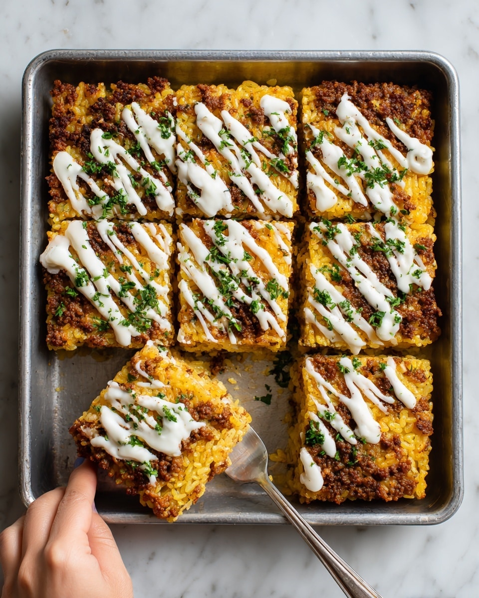 The image shows a square metal baking pan with four pieces of crispy, golden-yellow baked rice on top, arranged in a 2x2 grid. A woman's hand is lifting out one square piece with a fork, revealing a hidden layer of cooked ground meat underneath the crispy rice layer. The top rice layer is evenly textured and browned on the edges, topped with drizzles of white sauce and scattered green herbs, adding fresh color contrast. Some white sauce is dolloped thickly on one section while thin lines of sauce streak across the other three pieces. The whole dish rests on a white marbled surface. Photo taken with an iphone --ar 4:5 --v 7