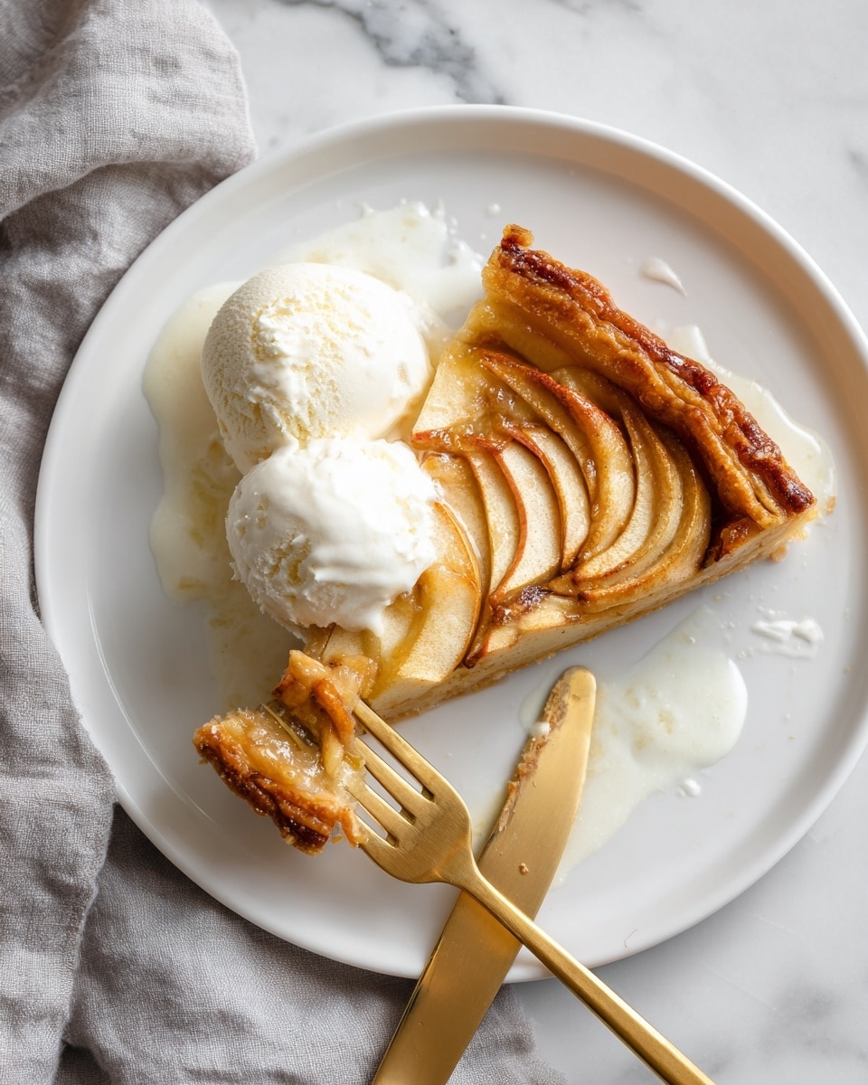 A white plate with a piece of golden brown apple tart that has a flaky crust and thin apple slices on top arranged in a layer, covered partly with melting white ice cream. There is a scoop of ice cream next to the tart, slightly melting and spreading creamy white liquid around it. A fork is cutting into the tart, lifting a small piece, and a golden knife is placed on the plate near the ice cream. The plate is on a white marbled surface with a soft gray cloth nearby. photo taken with an iphone --ar 4:5 --v 7
