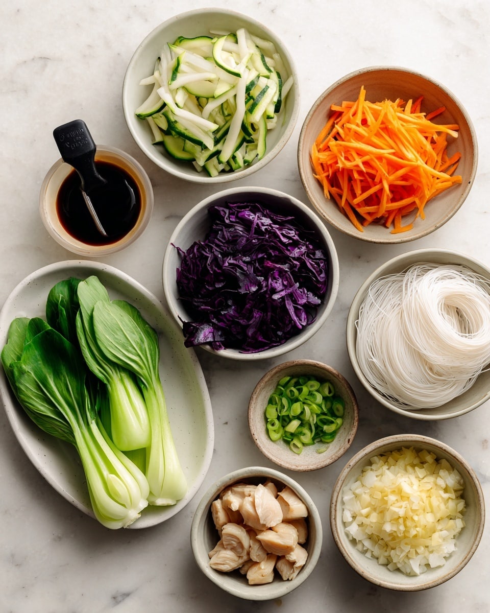 Several bowls and a white oval plate hold different fresh ingredients on a white marbled surface. The white oval plate at the left has bright green bok choy leaves. Moving clockwise, a bowl with white and green sliced zucchini sits at the top. Next to it is a bowl filled with thin orange carrot strips with a black measuring spoon resting inside. Beside the carrots is a small bowl of chopped thin green onions. To the right of the onions are two bundles of fine, white rice noodles. Below the noodles is a bowl with sliced pale green cucumber sticks. At the bottom center is a bowl of light beige chicken pieces. To the left of the chicken is a small bowl with dark soy sauce. Above this is a bowl of deep purple shredded cabbage. In the middle is a bowl filled with chopped white onions, and just under it is a very small bowl of minced pale yellow garlic. The setup is neat and colorful, showing fresh vegetables and ingredients ready for cooking, photo taken with an iphone --ar 4:5 --v 7