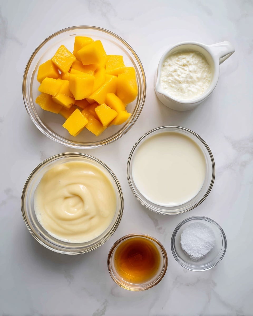 The image shows five clear glass bowls with different ingredients arranged neatly on a white marbled surface. The top left bowl is filled with bright yellow mango cubes. Next to it on the right is a small measuring jug with pale whipping cream with light froth on top. Below the mango bowl is a larger bowl filled with smooth, creamy, pale yellow sweetened condensed milk. To the right of that is a small bowl with fine white salt, and next to it is the smallest bowl with a golden-brown vanilla liquid inside. Each bowl is clearly labeled in bold black text above or near it. photo taken with an iphone --ar 4:5 --v 7