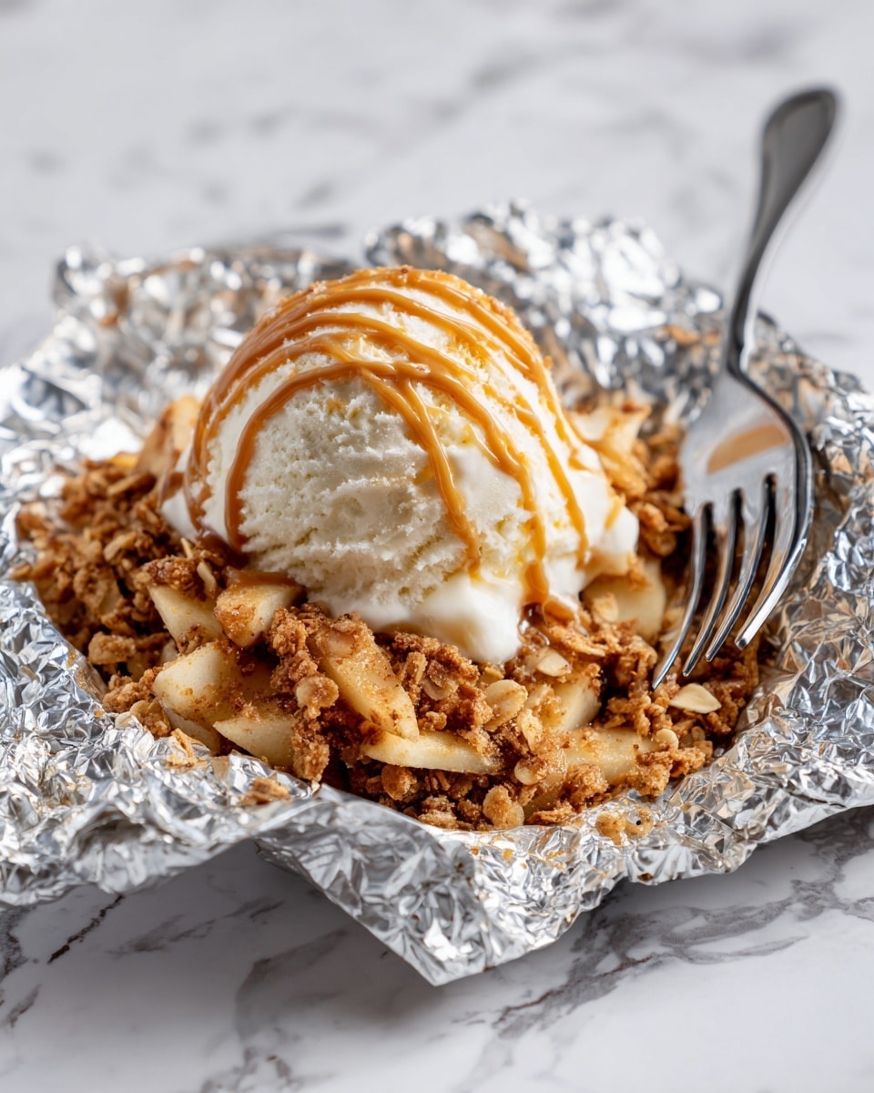 A close-up of a dessert featuring a single scoop of creamy white ice cream with light caramel drizzle on top, resting on a base of golden brown crumbly oats and nut topping mixed with cinnamon-dusted cooked apple slices, all placed inside a shiny foil wrap on a white marbled surface, with a silver fork partially visible under the crumble. Photo taken with an iphone --ar 4:5 --v 7