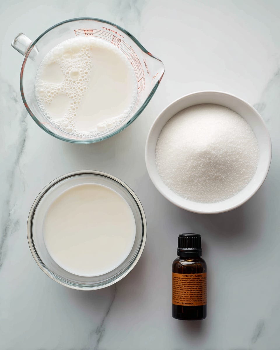 The image shows four items on a white marbled surface. At the top left, there is a clear glass measuring cup filled with white liquid, likely milk or cream, with small bubbles on the surface. To the right of it, there is a white bowl filled with fine white sugar, smooth and even on top. Below the glass measuring cup, there is another clear glass measuring cup holding a creamy white liquid with a few bubbles on top. Lastly, a small dark brown bottle with an orange label lies on the bottom right, labeled as caramel flavor. The arrangement is clean and simple. photo taken with an iphone --ar 4:5 --v 7