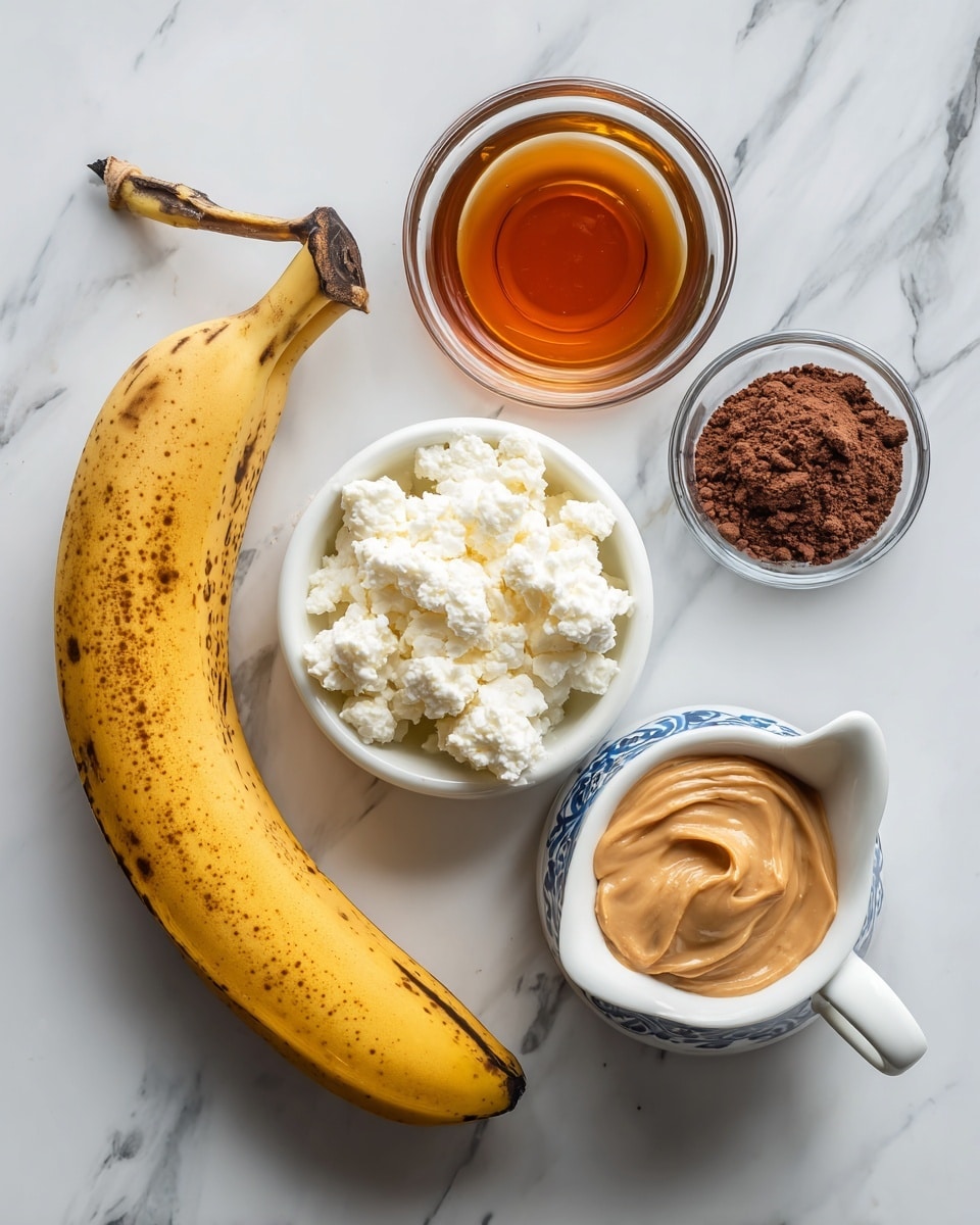 A fresh whole banana with yellow skin and a few brown spots lies on a white marbled surface next to a small clear glass bowl filled with white, chunky cottage cheese. Nearby, a small white bowl holds creamy light brown peanut butter, and a tiny glass bowl contains fine dark brown cocoa powder. A small clear glass cup of amber maple syrup sits beside these, and a white ceramic jug with a blue pattern around the rim is filled with milk. All items are spaced out neatly on the white marbled surface, lit softly from above. photo taken with an iphone --ar 4:5 --v 7