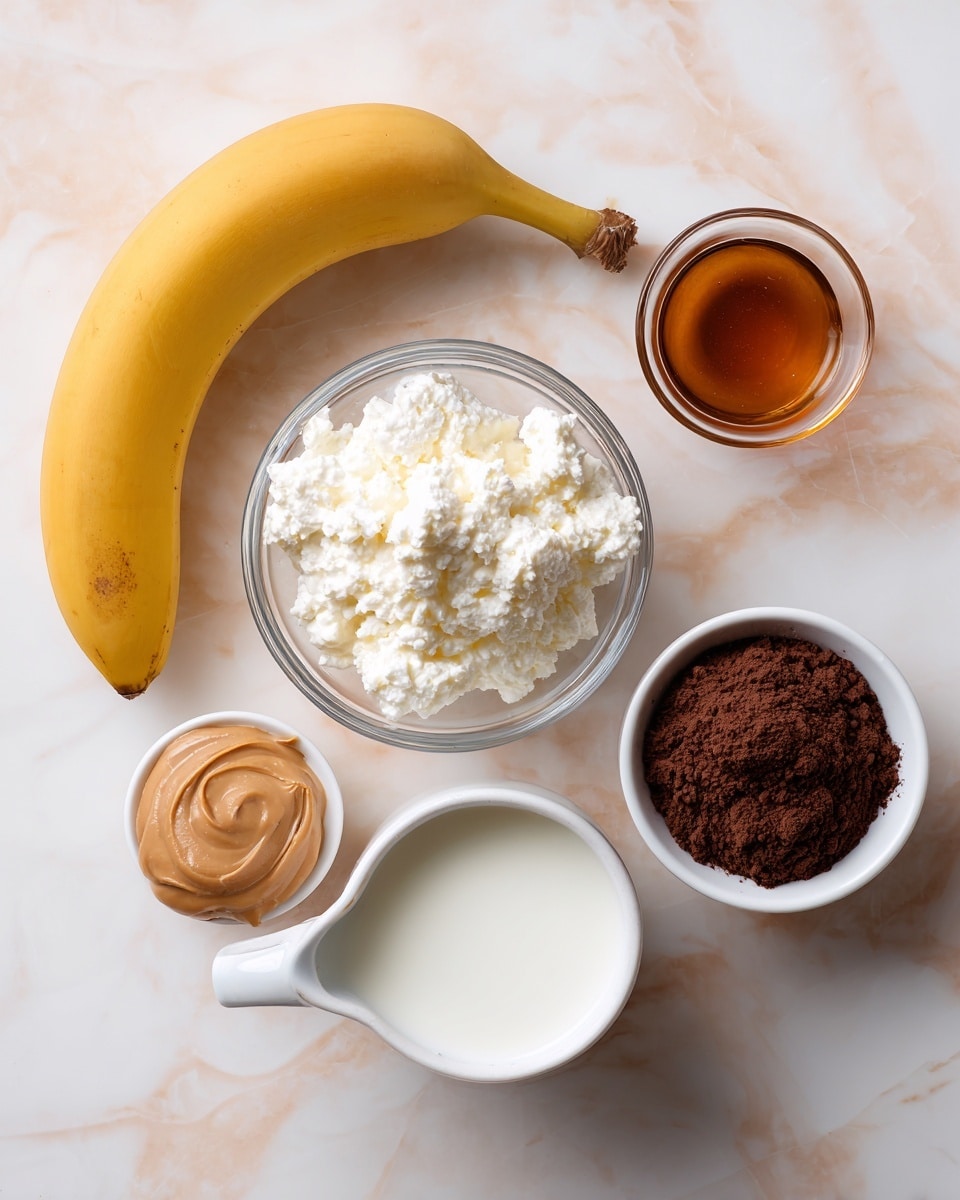 A simple arrangement on a white marbled surface shows a whole yellow banana curved to the left near the top left. At the center is a clear small round bowl filled with white cottage cheese with a soft, lumpy texture. Near the top right is a small glass cup with light brown maple syrup. To the right is a white small bowl holding smooth, light brown peanut butter. At the bottom right is a tiny clear bowl containing dark brown cocoa powder. At the bottom left is a white pitcher filled with white milk, showing a bit of a glossy reflection. The whole setup is laid out clearly with soft, natural light photo taken with an iphone --ar 4:5 --v 7