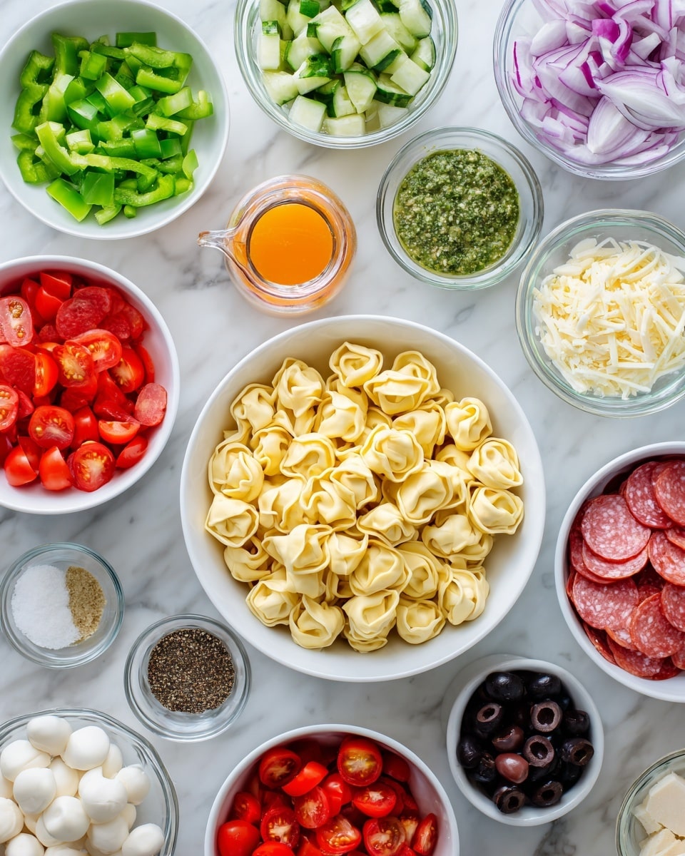 A flat lay of many small white bowls on a white marbled surface holding different ingredients for a pasta salad, centered by a large white bowl filled with pale yellow cheese tortellini. Around it, clockwise from top left, are diced green pepper with a bright green color, chopped fresh basil leaves in a deeper green, a clear glass jug with orange Italian salad dressing, chopped light green cucumber pieces, finely grated light yellow Parmesan cheese, a small white bowl with green pesto sauce, a white bowl filled with red and white slices of red onion, a white bowl with white round mozzarella cheese pearls, a white bowl of chopped red salami, a small white bowl of ground black pepper, a small white bowl of white salt, a white bowl with bright red cherry tomatoes cut in halves, another white bowl with black olive slices, and diced red pepper with a vibrant red color. Photo taken with an iphone --ar 4:5 --v 7