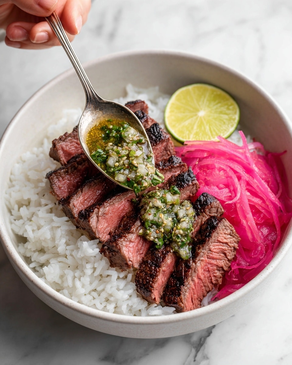 A white bowl sits on a white marbled surface filled mostly with a bed of fluffy, white rice that takes up the bottom half. On top, there are five slices of medium-rare steak, with a brown, slightly charred outside and pink inside, fanned out in the center. On the right side of the bowl, bright pink pickled onions add a pop of color next to the steak. A wedge of lime with a yellow-green inside sits near the steak. A silver spoon held by a woman's hand is placing a green herb sauce with chopped onions and a shiny oily texture onto the steak, adding freshness and contrast. Photo taken with an iphone --ar 4:5 --v 7