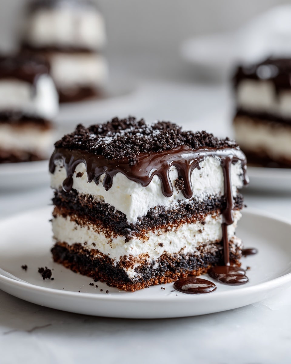 The image shows a slice of layered dessert with five visible layers of dark chocolate cookie pieces alternating with four layers of soft, white cream. The top layer is covered with crushed dark cookie crumbs and drizzled with thick, glossy dark chocolate sauce that slightly drips down the sides. The dessert sits on a simple white plate placed on a white marbled surface. In the background, there are blurred slices of the same dessert on white plates. The lighting is soft with a close-up focus on the front slice photo taken with an iphone --ar 4:5 --v 7