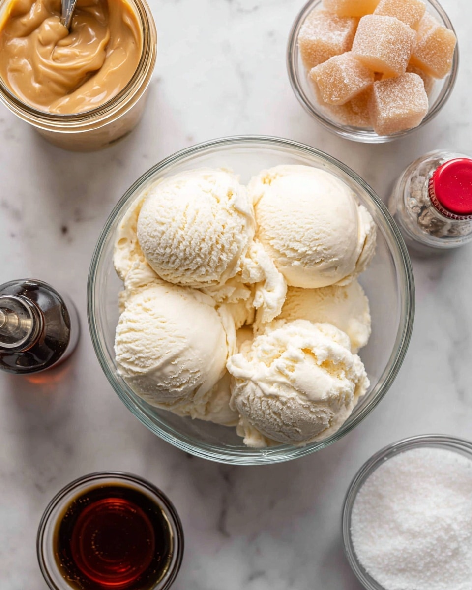 The image shows a clear glass bowl in the center filled with six scoops of creamy vanilla ice cream in soft white and light yellow colors, set on a white marbled surface. Above the bowl to the right is a small clear glass bowl filled with cream soda ice cubes, which are light brown and have a bubbly texture. Above the ice cream bowl to the left is a transparent jar filled with smooth butterscotch topping in a rich caramel color. Below the jar is a small measuring cup containing cream soda, with a dark amber color and tiny bubbles visible inside. To the left of the ice cream bowl is a piping bag filled with white whipped cream, positioned with the metal tip pointing toward the bowl. To the far left, there is a small dark bottle of rum extract with a red cap lying on the surface. Near the center right is a small clear bowl of white salt, and nearby another small dark bottle with a red cap is placed on the marbled surface. photo taken with an iphone --ar 4:5 --v 7