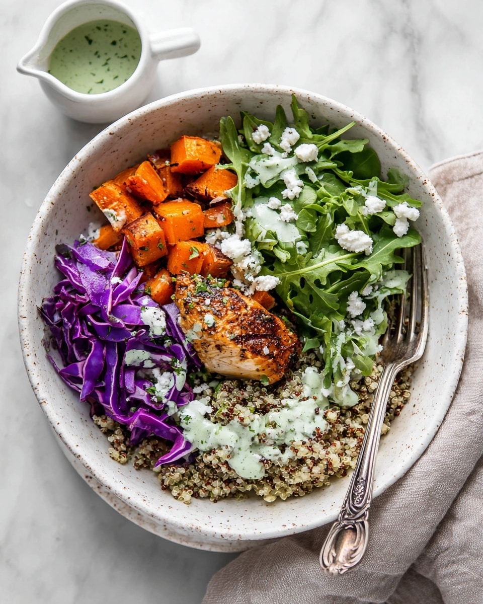 A white speckled bowl holds a colorful layered meal arranged in sections, starting with orange roasted sweet potato pieces on the bottom left, next to a golden-brown seasoned chicken piece in the center-right, separated by a portion of light beige quinoa with green herbs sprinkled on top at the bottom right, and topped with fresh green arugula leaves and purple shredded cabbage along the upper half. The dish is finished with white crumbled cheese and a creamy green dressing drizzled over the greens, all placed on a white marbled surface. A decorative silver fork rests on the edge of the bowl, angled into the food, with no woman's hand visible. A small white ceramic cup with green dressing is placed nearby. Photo taken with an iphone --ar 4:5 --v 7