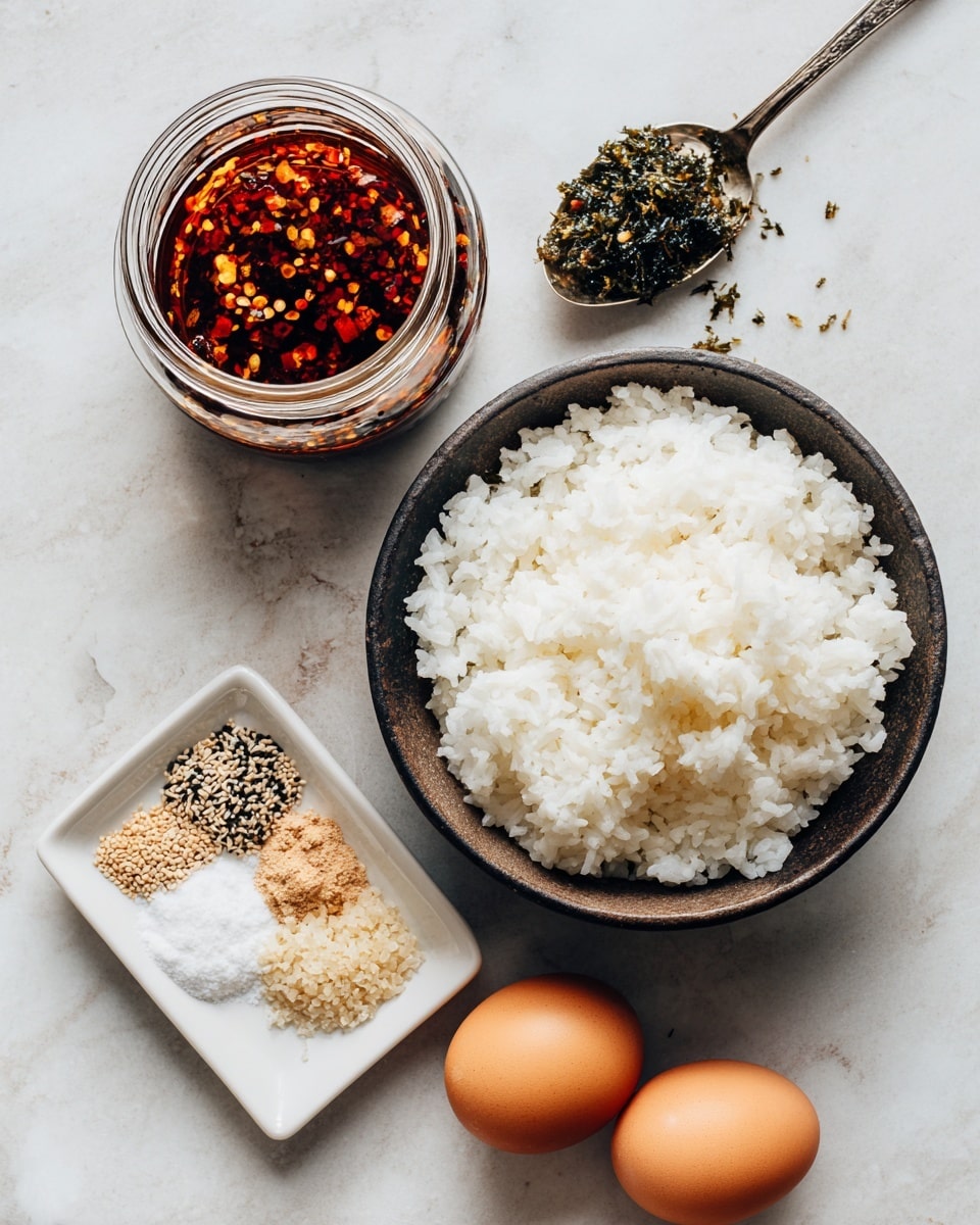 A dark bowl filled with fluffy white rice sits on a white marbled surface, next to an open jar of chili oil with visible red flakes inside. Beside the jar, a small white square dish holds three piles of seasonings in neat sections: pale tan sesame seeds, black sesame seeds, and coarse white salt. Two brown eggs are placed near a silver spoon, which carries a dark green and slightly crumbly seaweed mixture with light-colored spice bits. The setup is clean and bright with natural lighting. photo taken with an iphone --ar 4:5 --v 7