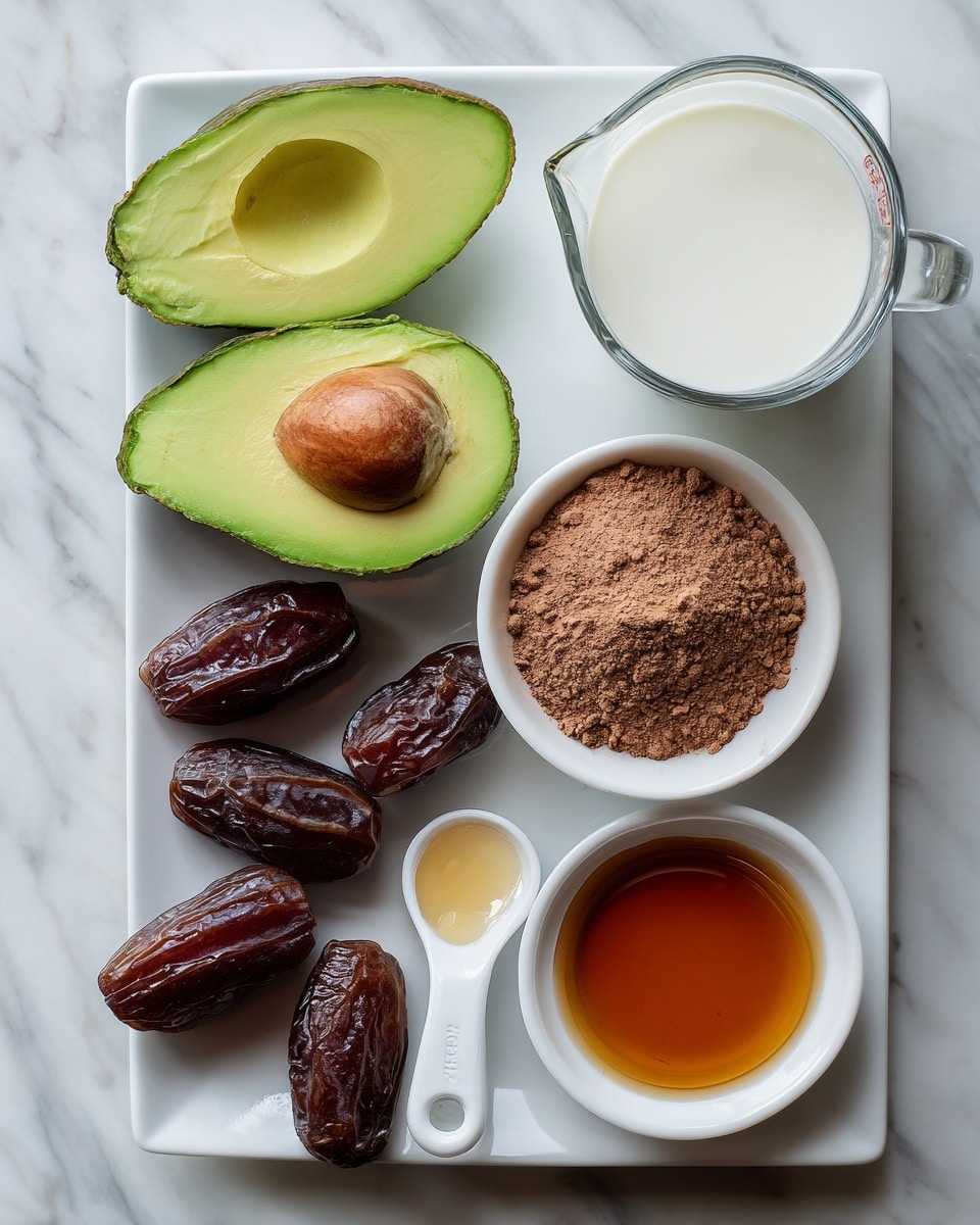A white rectangular plate holds two halves of a green avocado with a soft texture and one half showing the seed, next to several dark brown dates with a glossy texture. To the right, a clear glass measuring cup contains white coconut milk with a smooth surface. Below it, a white bowl filled with light brown cacao powder has a powdery and slightly clumpy texture. Next to the cacao powder, a white measuring spoon with a light brown liquid vanilla extract sits on the white marbled surface. Below these, a white bowl contains amber-colored maple syrup with a shiny, smooth surface. All items are arranged neatly on a white marbled background photo taken with an iphone --ar 4:5 --v 7