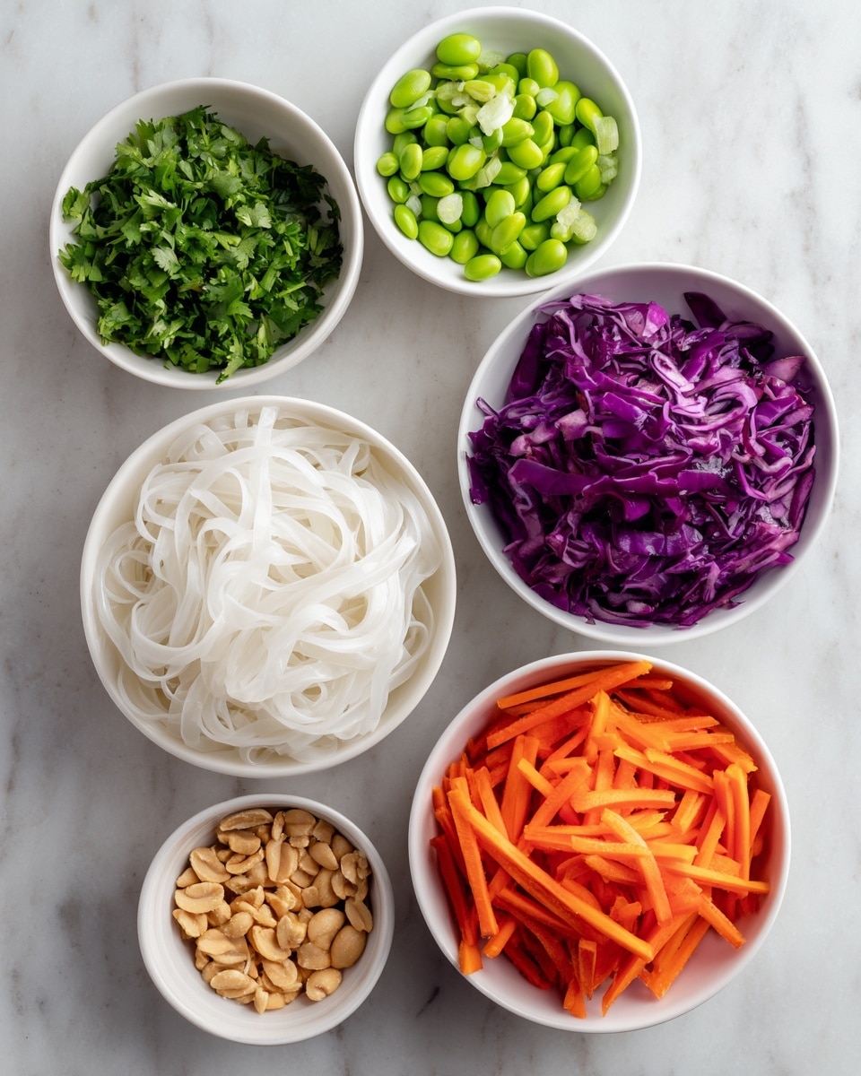 The image shows six white bowls arranged on a white marbled surface, each filled with a different colorful ingredient. The top row has three small bowls: the left one contains chopped green cilantro, the middle one is filled with sliced bright green scallions, and the right one holds whole green edamame beans. Below them, there are three larger white bowls: the left bowl is full of smooth, white rice noodles loosely piled, the middle bowl holds thinly sliced vibrant purple red cabbage, and the right bowl contains thin, bright orange carrot sticks. In the lower left corner, a small white bowl is filled with crushed light brown peanuts. The colors are vivid and fresh, with the bowls evenly spaced and viewed from above. Photo taken with an iphone --ar 4:5 --v 7