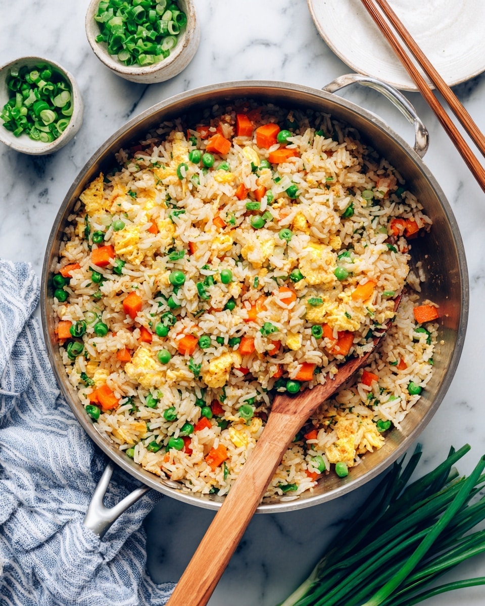 A white plate is filled with three layers of fried rice, each with a mix of small green peas, diced orange carrots, yellow scrambled egg pieces, and bits of white onions, all evenly spread. The rice is light brown from soy sauce, creating a warm, textured look. Dark brown wooden chopsticks rest diagonally on the right side of the plate. The plate sits on a white marbled surface, with a striped cloth napkin on the left holding two more chopsticks. Around the plate are small bowls, one with dark soy sauce and another wooden bowl filled with chopped green onions. photo taken with an iphone --ar 4:5 --v 7