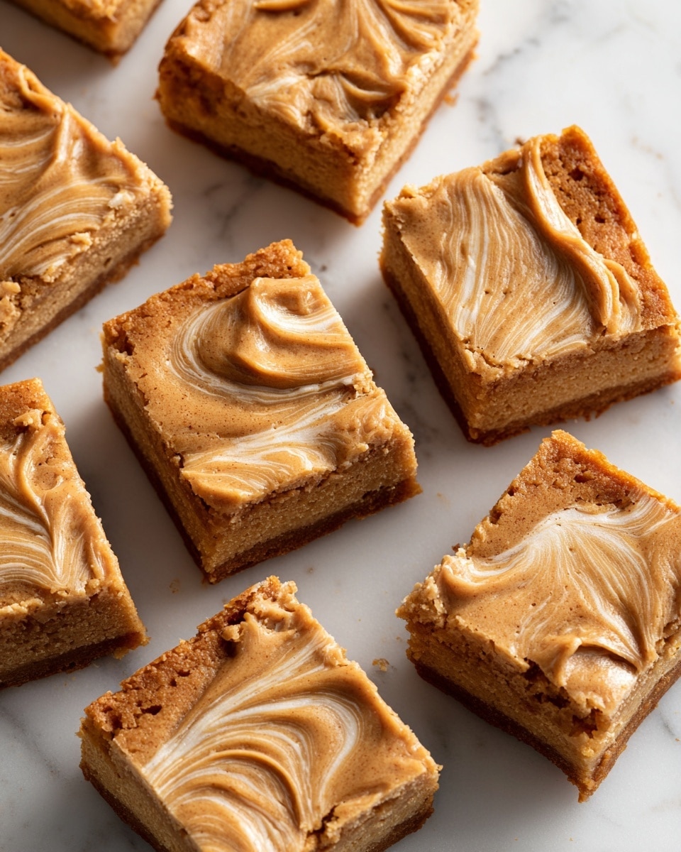 The image shows a stack of four square brownies with a light brown swirl pattern on the top layer, giving them a textured look. The brownies have a soft, slightly cracked surface with a crumbly texture. Around the stack are more brownies placed flat on a white marbled surface, and several oval-shaped Biscoff cookies with a ridged edge and branded lettering on top. A red and white Biscoff package lies on the side, partially open with a cookie visible inside. The overall colors range from light to medium brown with warm tones. photo taken with an iphone --ar 4:5 --v 7