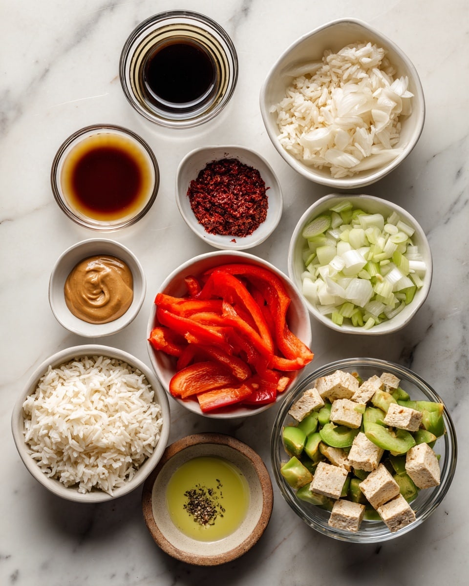 The image shows a white marble surface with several white bowls and a small brown bowl arranged in a loose circle. Starting at the top center, a small clear glass holds a dark brown liquid labeled toasted sesame oil. Just below it, in a small stainless steel bowl, is a dark red powder called red curry paste. Directly below is a small clear bowl containing a dollop of smooth light brown peanut butter. To the right of that is a white bowl with diced white onions. Below the onions, small light brown cubes labeled tempeh sit in a small brown bowl. To the right of the tempeh is a small clear bowl with a light yellow liquid labeled avocado oil, and below that is another white bowl with a light brown liquid called soy sauce. On the bottom left, a white bowl is filled with thin slices of bright red peppers. Above the red peppers is a white bowl of cooked white rice. In the center, a clear bowl holds a mix of colorful stir-fry vegetables including orange, green, white, and red pieces. Some black pepper is sprinkled on the white marble near the center. photo taken with an iphone --ar 4:5 --v 7