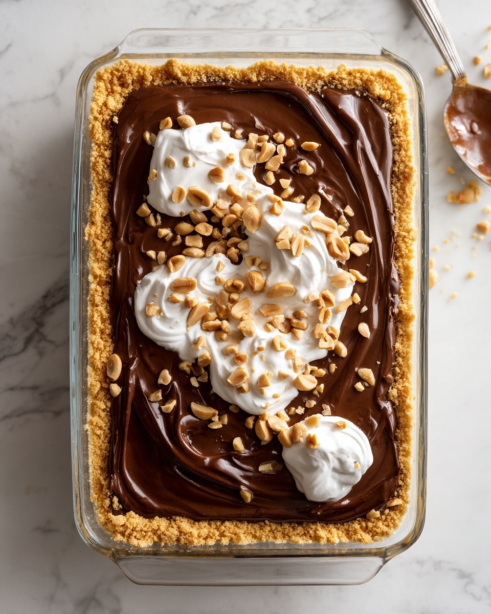 A four-step visual of a dessert layered in a clear rectangular glass dish placed on a white marbled surface. The first layer is a crushed golden biscuit or cookie base, spread evenly, with a crumbly texture covering the bottom. The second layer is a thick, smooth, dark brown chocolate layer spread over the biscuit base, covering it completely. The third layer shows a mix of caramel sauce and dollops of creamy white whipped topping placed unevenly on the chocolate layer, creating a swirling effect of caramel and cream. The final layer is a glossy chocolate spread over the caramel and cream, sprinkled generously with roughly chopped light brown peanuts scattered across the surface for texture and color contrast. photo taken with an iphone --ar 4:5 --v 7