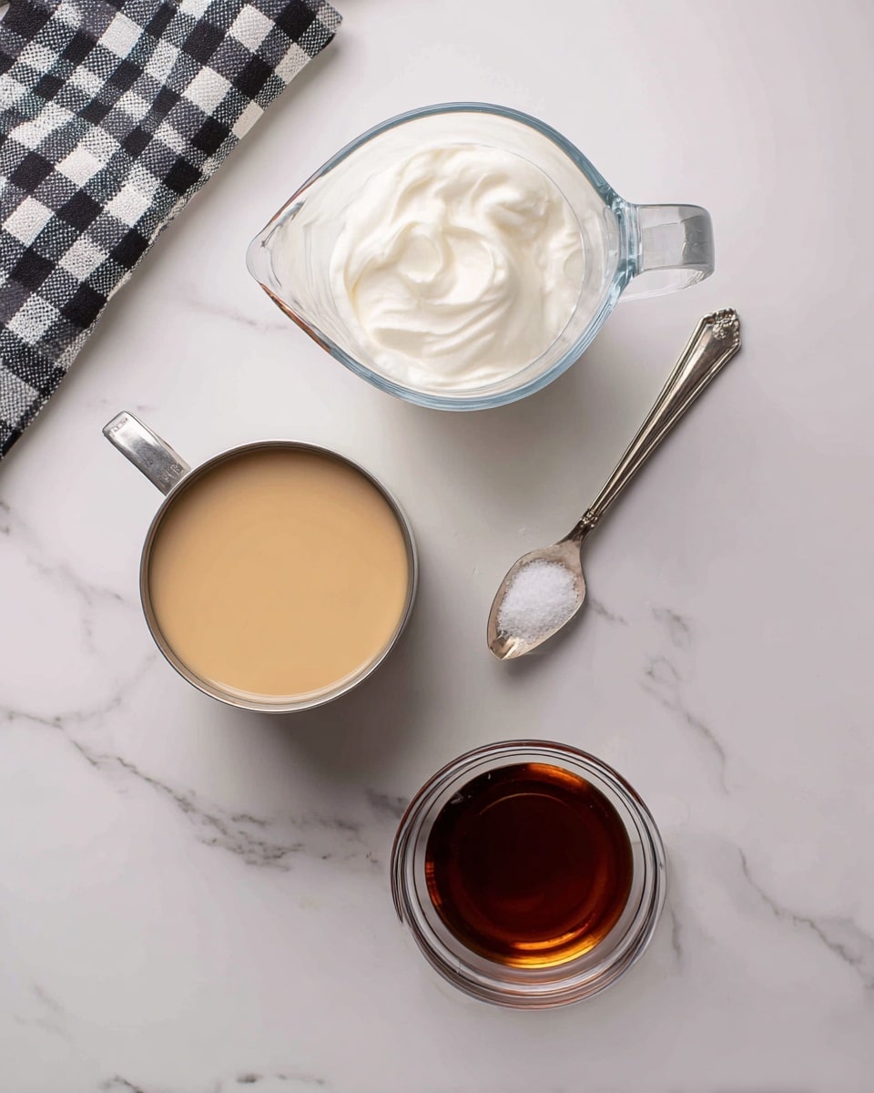 A flat lay image showing four ingredients on a white marbled surface: at the top is a clear glass measuring cup filled with white whipping cream; below it on the left is an open 14 oz can of light beige condensed milk; to the right of the can is a small silver measuring spoon holding a pinch of white salt; at the bottom right is a clear small bowl containing a dark amber liquid labeled vanilla; a black and white checkered cloth is partially visible at the top left corner. Photo taken with an iphone --ar 4:5 --v 7